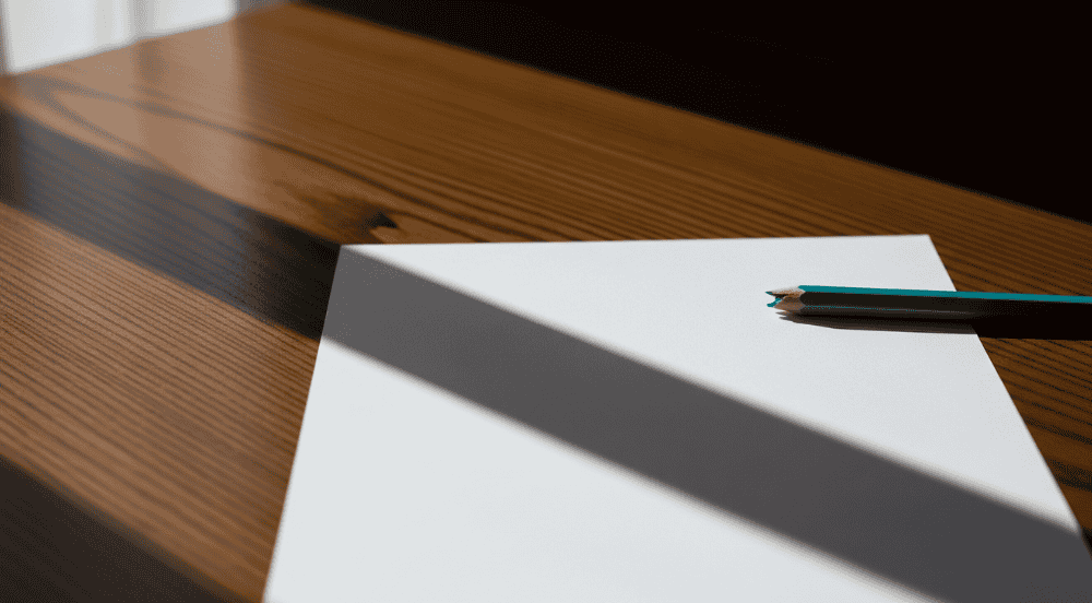 Um lápis de cor quebrado sobre uma folha em branco, simbolizando a frustração e o potencial contido nos desafios de aprendizagem de uma criança.